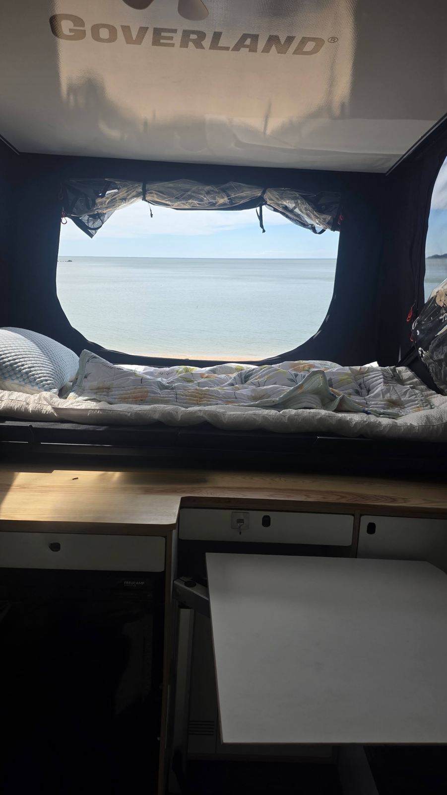Спальное место под подъёмной крышей и окно с видом на море